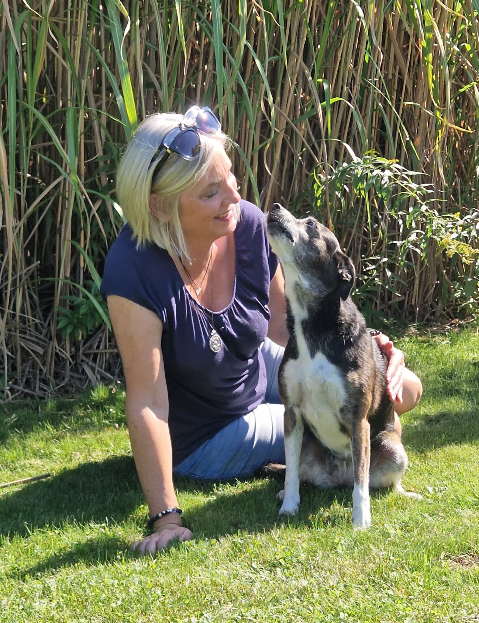 Carmen Kihm sitzt mit ihrer Hündin im Garten und beide schauen sich vertraut an.